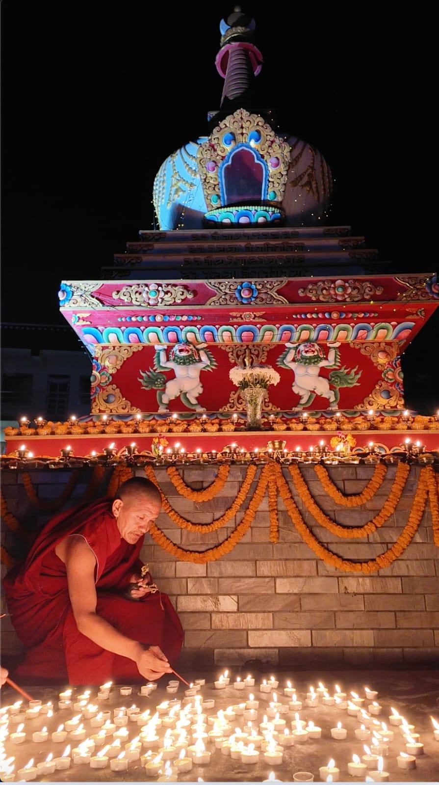 Monk lighting butter lamps at the stupa, Segyu Monastery